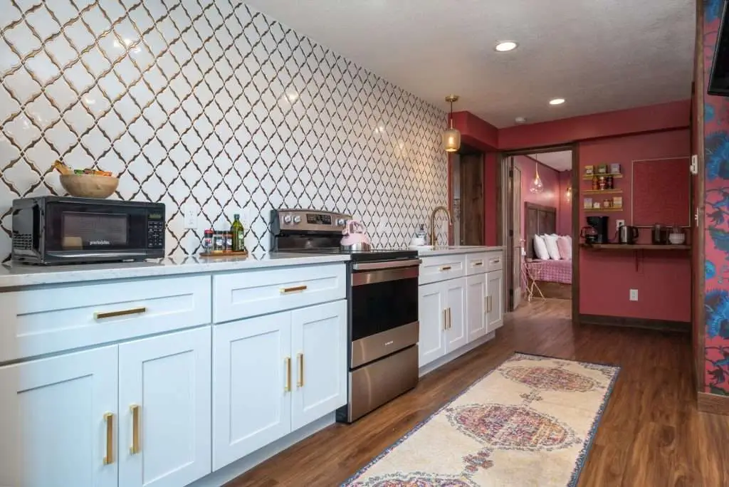 Full kitchen with white cabinets and stainless appliances
